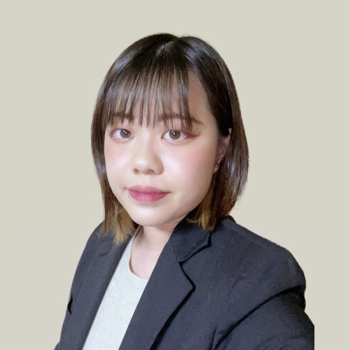 ボブヘアの女性がジャケットを着ている、明るい背景。