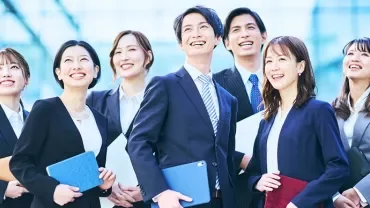現代的な建物の外に立つ笑顔のプロフェッショナルたち。