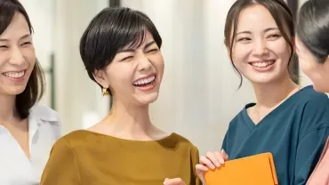 室内で楽しそうに会話をする4人の女性。