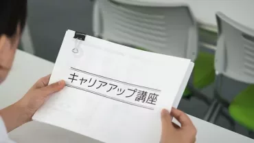 人がオフィスで資料を持っている様子。