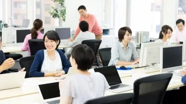 現代的なオフィスで働き話している人々。
