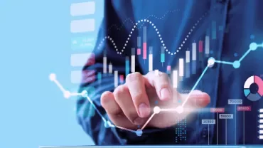 デジタル表示された金融チャートに触れる手。