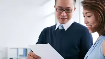 An employer showing his employee a well-written reference letter.