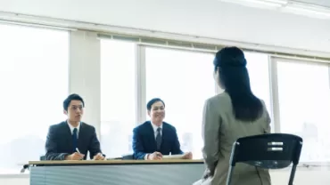 Job interview with two male interviewers and a female candidate.