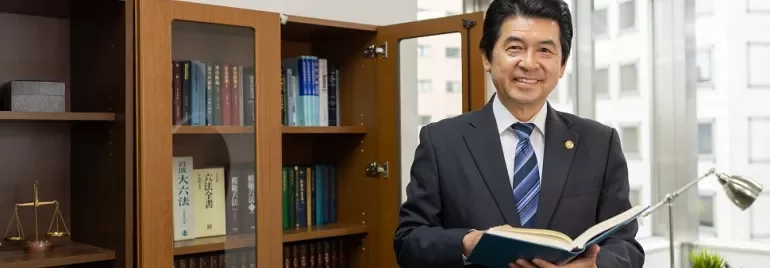 オフィスで本を手に持つスーツ姿の男性。