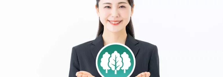 環境保護を象徴する木のアイコンを手に持つ女性。