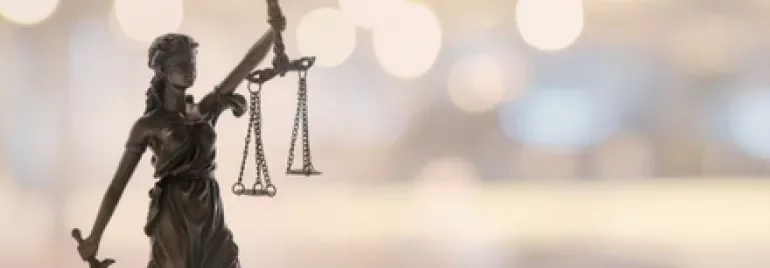 ぼやけた背景に立つ正義の女神像。