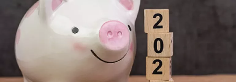 豚の貯金箱の横に積まれた2020年の木製ブロック。