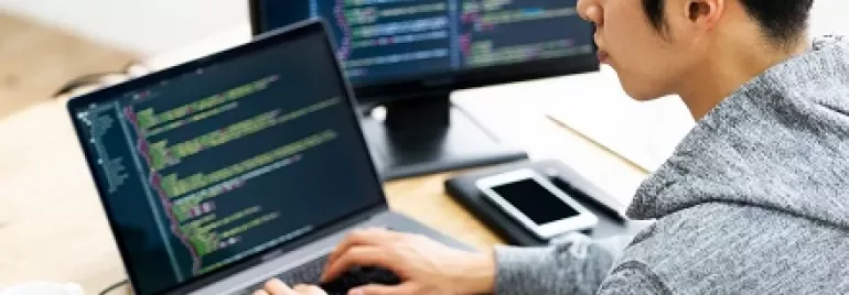ラップトップでコードを書く人。