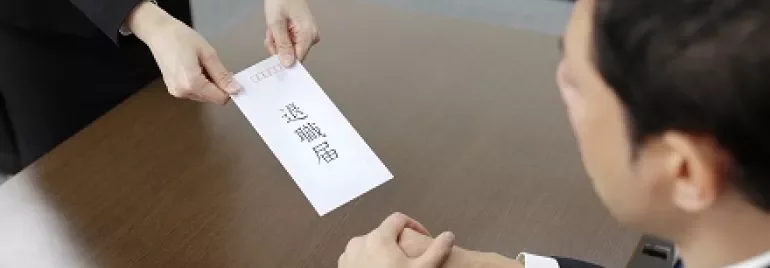 オフィスで辞職届を手渡す様子。
