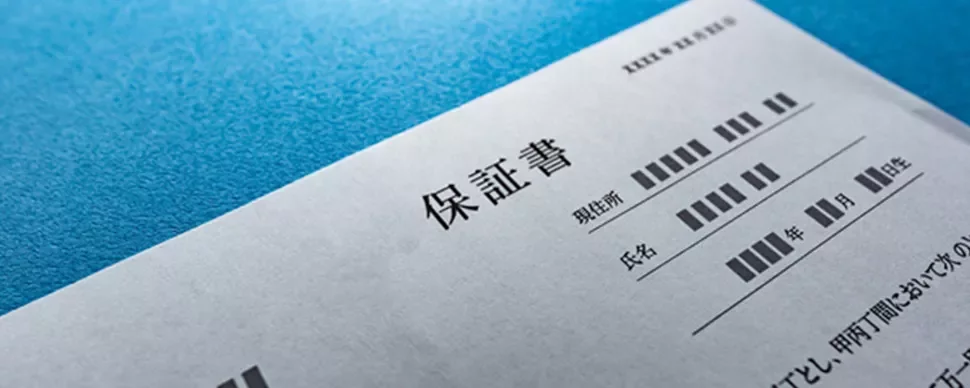 Close-up of a Japanese document with text and lines, against a blue background.