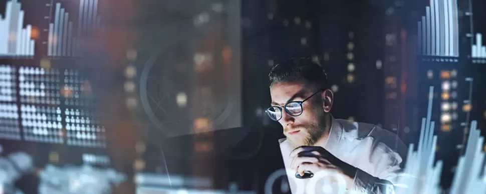 データを分析する男性、グラフが画面に表示されています。