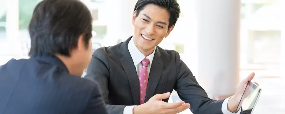 ビジネス会議でタブレットを見せる2人の男性。