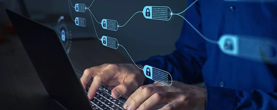 ブロックチェーンのデジタルグラフィックスが重ねられたノートパソコンを操作する人。