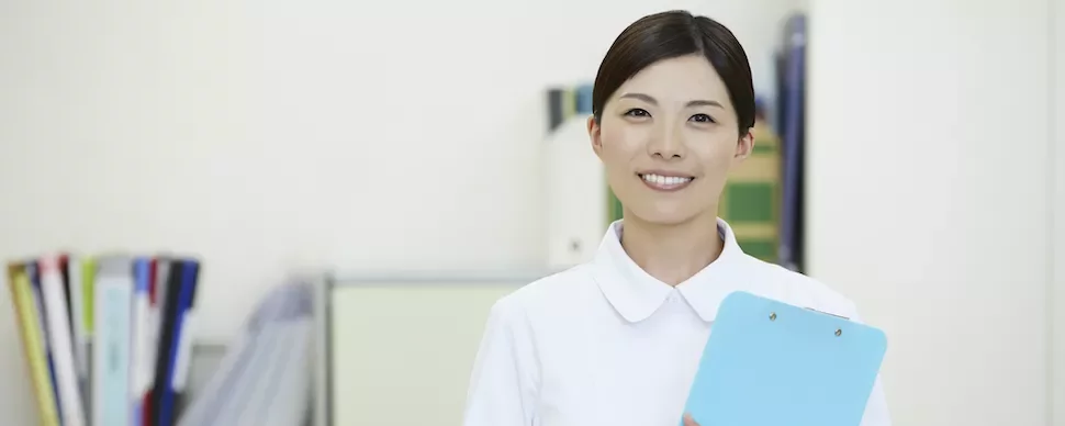 青いクリップボードを持つ笑顔のプロフェッショナル。