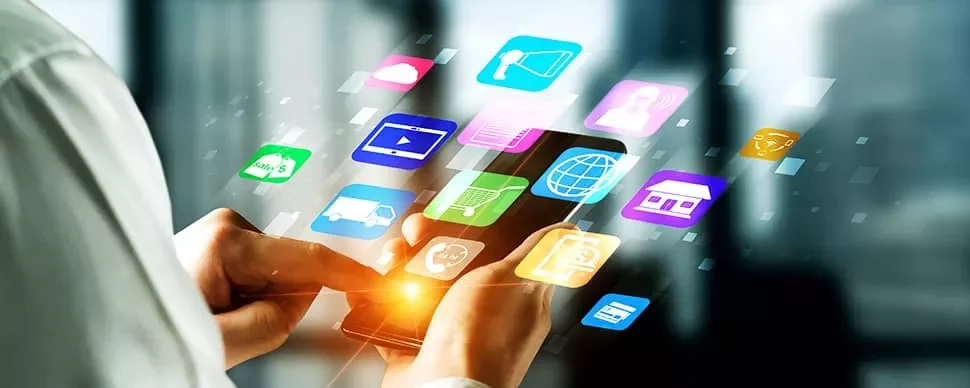 スマートフォンを使い、カラフルなアプリアイコンが浮かんでいる。