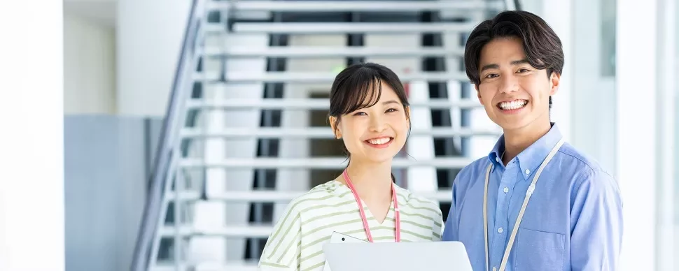階段の前で微笑む二人の人物。