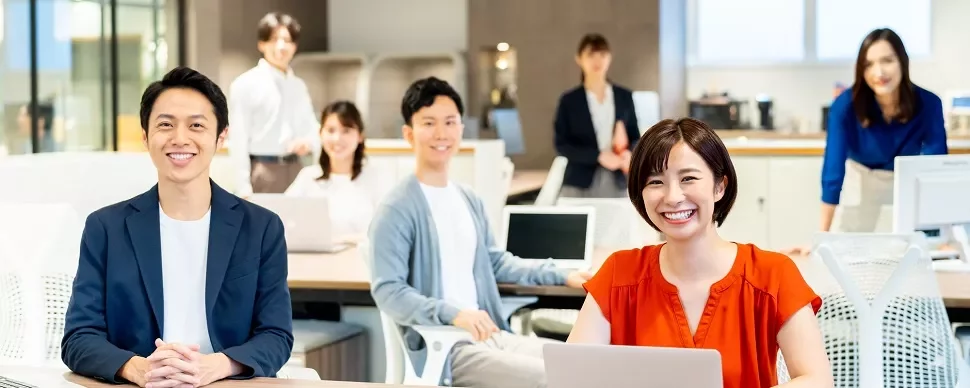 現代的なオフィスで微笑む6人のグループ。