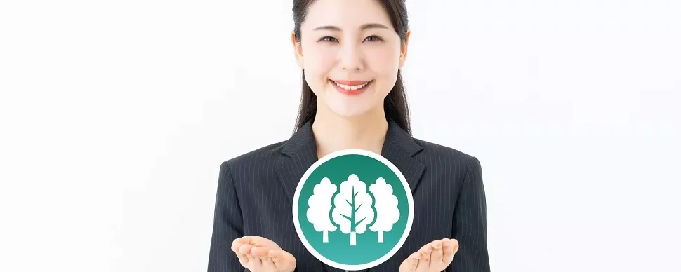 環境保護を象徴する木のアイコンを手に持つ女性。