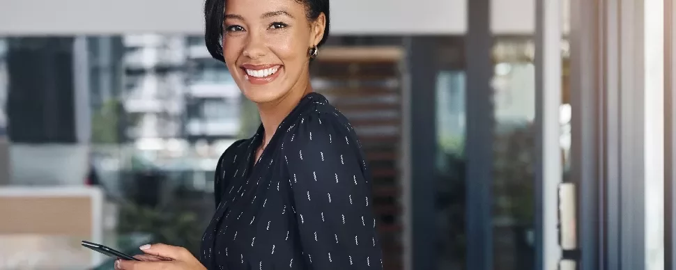 携帯電話を持った笑顔の女性、オフィス内。
