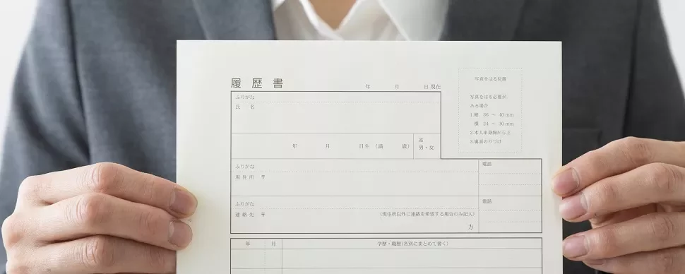 履歴書を持っているスーツ姿の人。
