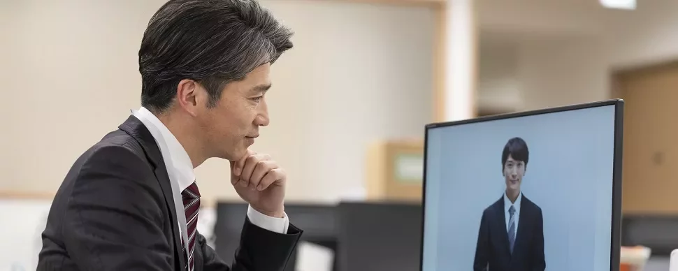 オフィスでビデオ通話をするスーツ姿の男性。