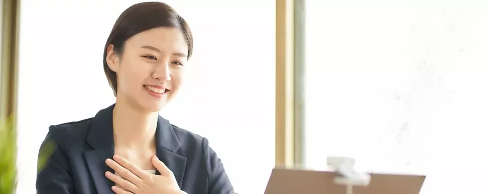 スーツを着た人が机でビデオ通話をしている