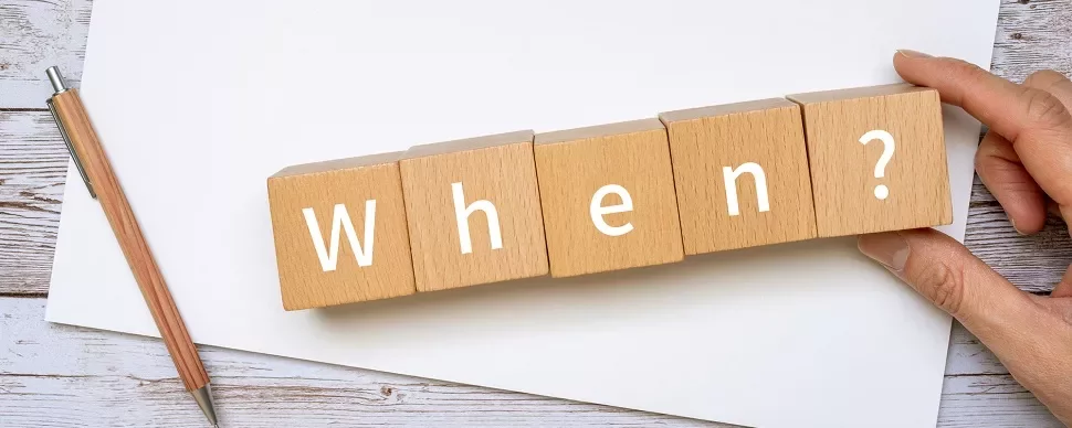 木のブロックに「When?」と書かれている。ペンが横にある。