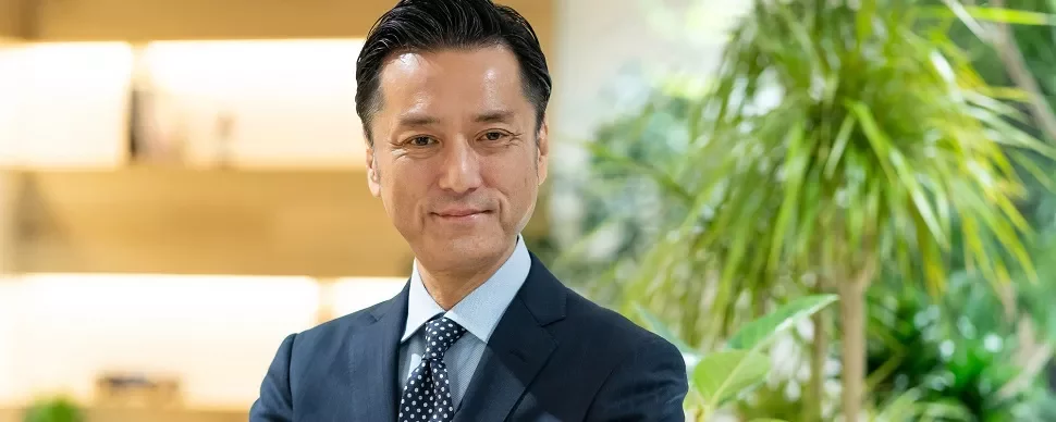 オフィスでスーツを着た男性が微笑んでいます。
