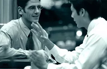 Two men in a business discussion at a desk.