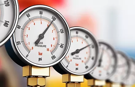 Close-up of multiple gas pressure gauges with needle indicators.