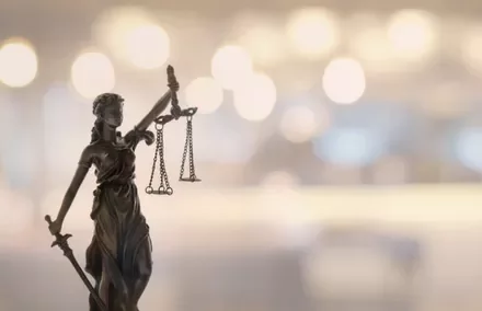 Lady Justice statue with scales and blurred background.
