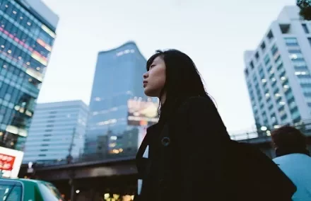 Person standing in urban cityscape with tall buildings.