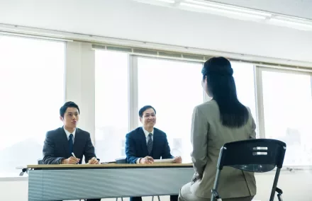 Job interview with two male interviewers and a female candidate.