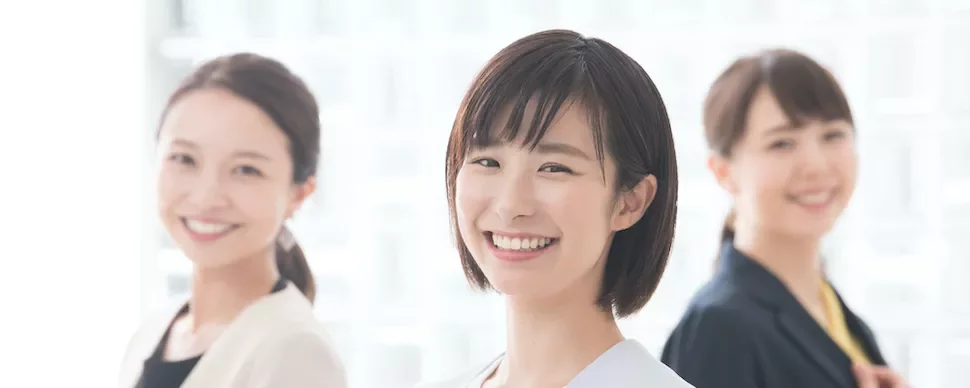 笑顔の3人の女性が明るい背景にいます。