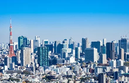 東京タワーと高層ビルが並ぶ東京のスカイライン、晴れ渡った青空が広がる。
