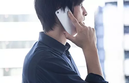Person talking on a smartphone, seen from the side.