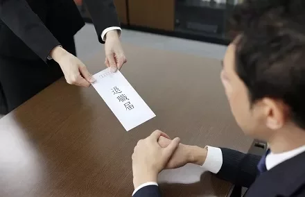 オフィスで辞職届を手渡す様子。